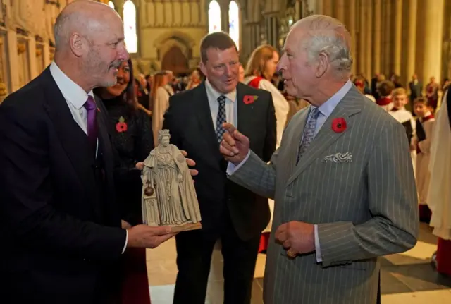 King Charles III being presented with miniature of statue