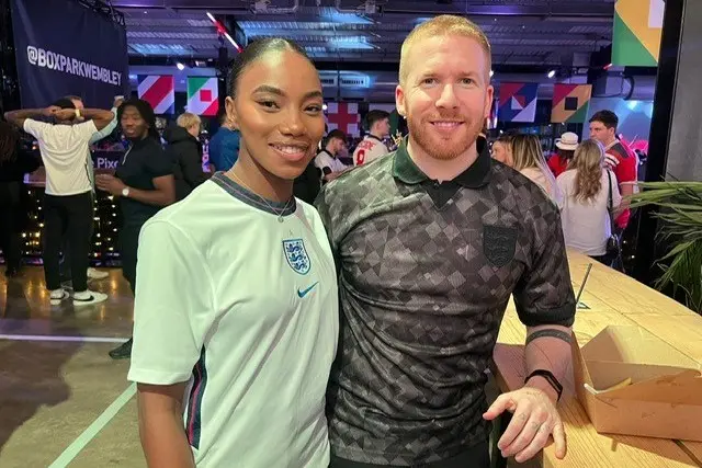 Chyna Mills and Neil Jones pose for a photo while wearing England shirts