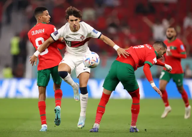 Joao Felix of Portugal battles for possession with Azzedine Ounahi and Hakim Ziyech