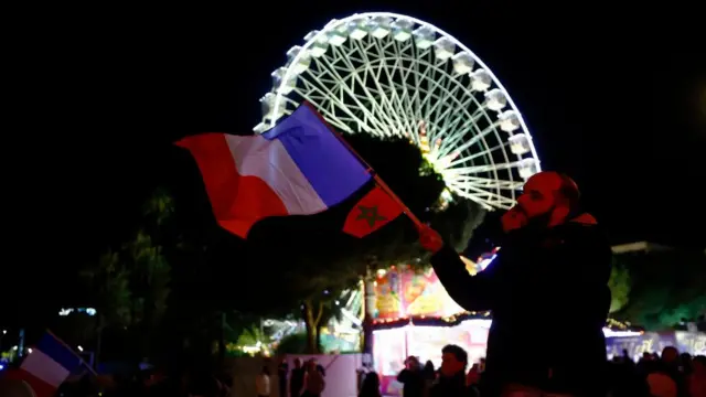 In Nice, southern France, a fan celebrates with a Morocco and France flag as France progress to the semi finals