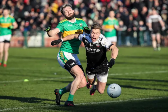 Kilcoo's Jerome Johnston takes a tumble after a challenge from Ryan Dougan