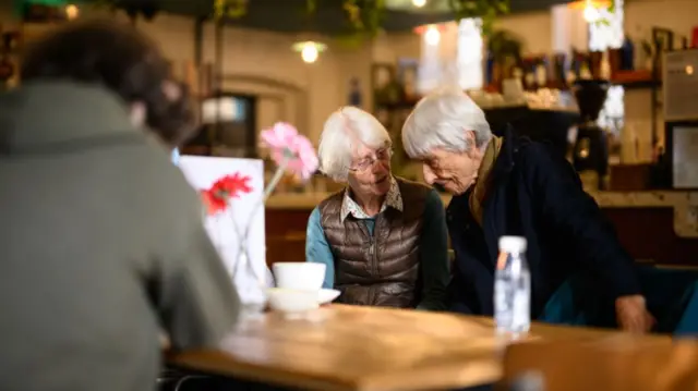 A group of friends socialise in the "A La Mesa" coffee shop within Jacksons Lane theatre in London, England.