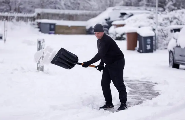 A man clears snow in Hertford