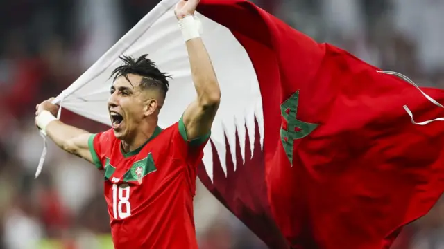 Jawad El Yamiq of Marrocco waves the Qatar and the Morocco flags as he celebrates after the FIFA World Cup 2022 quarter final soccer match between Morocco and Portugal at Al Thumama Stadium in Doha, Qatar, 10 December 2022.