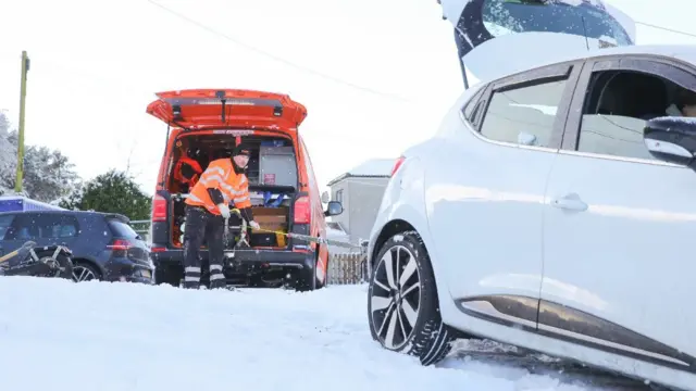 RAC workers dealing with a breakdown of a car in wintry conditions