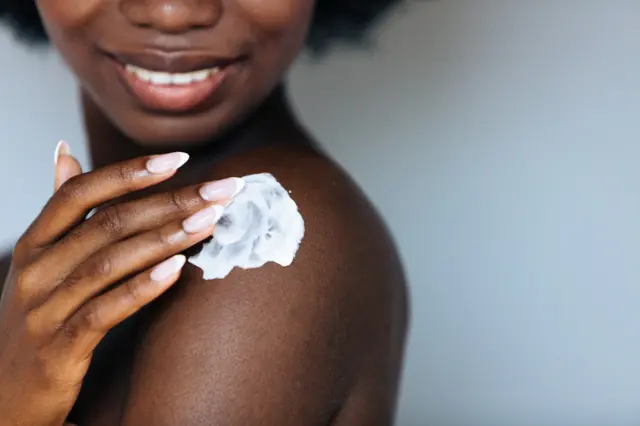 African woman applying cream