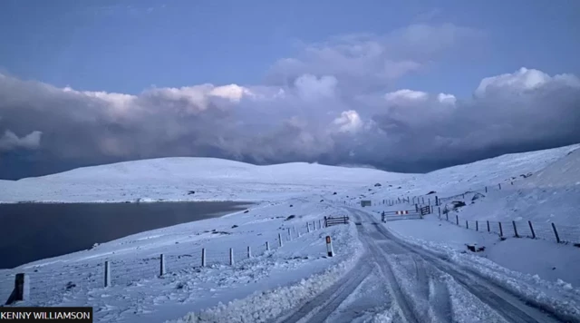 Snow covered the road and the hills at Eela Water in Shetland