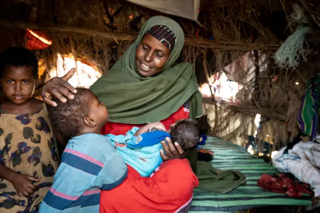 Somali mother Asiah Hussein Buule comforts three of her nine children in their makeshift hut in the Sebedow Camp, for Somalis displaced by drought and war, in November.