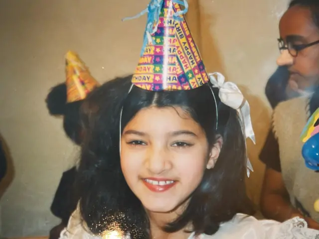 Zara Aleena as a child wearing a birthday party hat