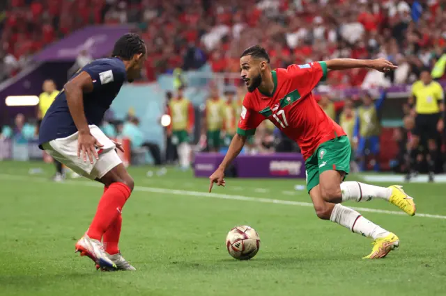 Sofiane Boufal of Morocco controls the ball against Jules Kounde of France during the FIFA World Cup Qatar 2022 semi final match between France and Morocco at Al Bayt Stadium