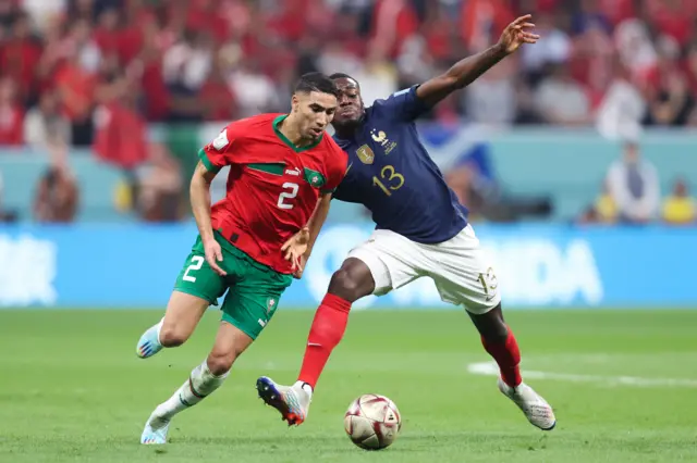 Achraf Hakimi of Morocco controls the ball against Youssouf Fofana of France during the FIFA World Cup Qatar 2022 semi final match between France and Morocco at Al Bayt Stadium