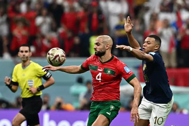 Morocco's midfielder #04 Sofyan Amrabat and France's forward #10 Kylian Mbappe fight for the ball during the Qatar 2022 World Cup semi-final football match between France and Morocco at the Al-Bayt Stadium in Al Khor