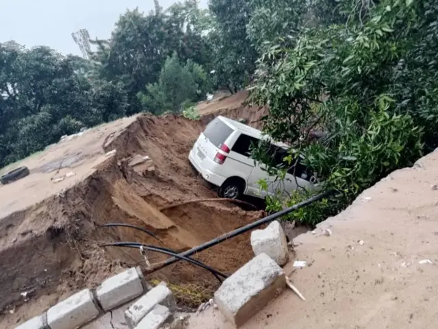 A damaged car is seen stuck after heavy rain cause flood in Kinsasha