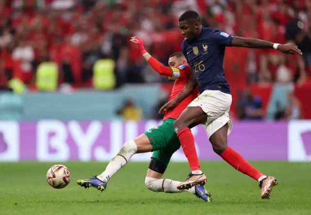 Marcus Thuram is tackled by Hakim Ziyech