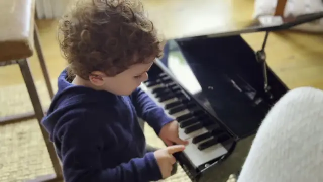 Archie playing on a toy piano