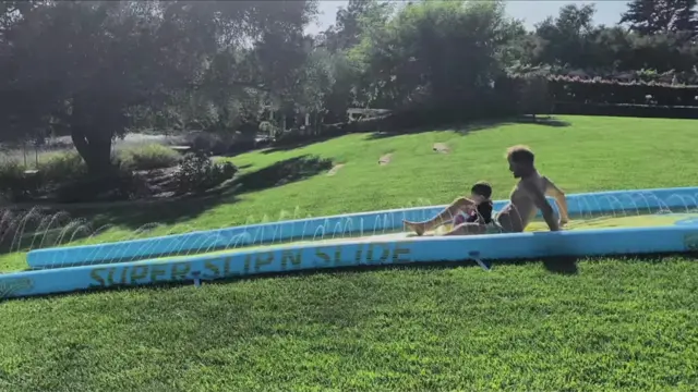 Harry plays with Archie on a waterslide in Episode six