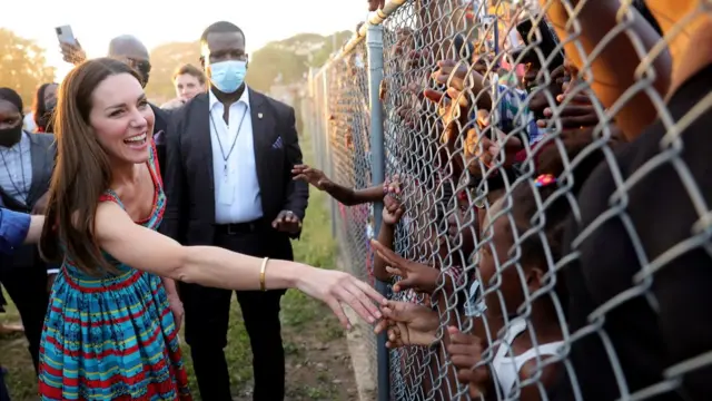 Kate, then Duchess of Cambridge, greeting people through a fence in Jamaica