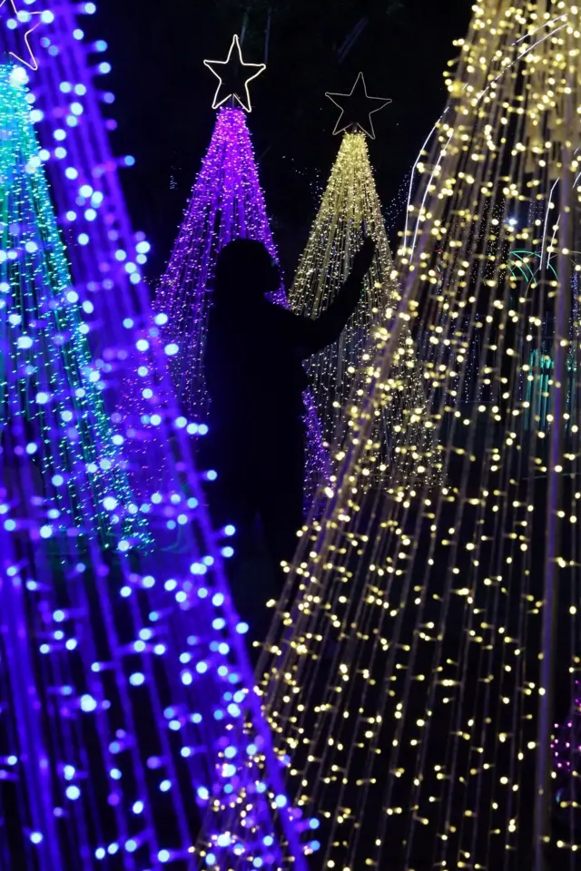 A woman takes a selfie next to lights at a Christmas village in Abuja, Nigeria.