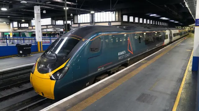 An empty platform and stationary train at Kings Cross station in London