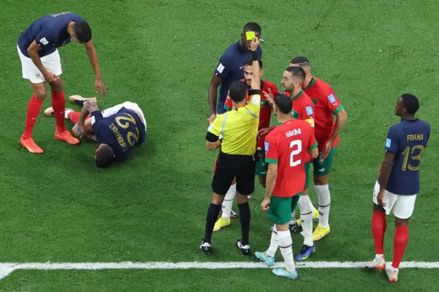 Morocco's midfielder #17 Sofiane Boufal (C) receives a yellow card from Mexican referee Cesar Ramos