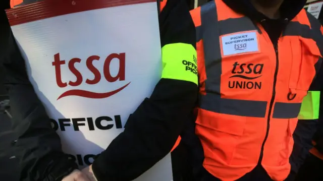 Workers from the Transport Salaried Staff Association (TSSA) union stand on the picket line at Euston station