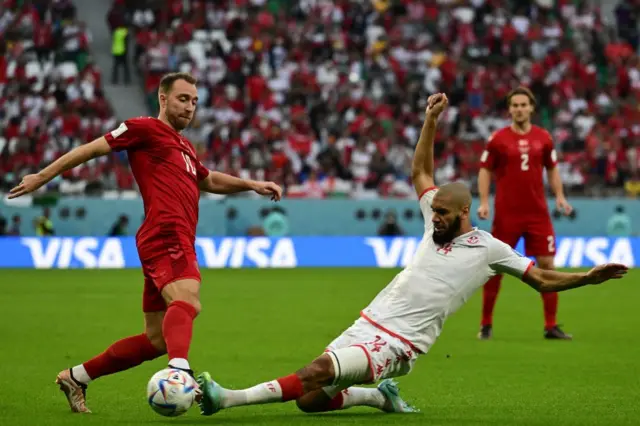 Denmark's midfielder Christian Eriksen (L) and Tunisia's midfielder Aissa Laidouni fight for the ball