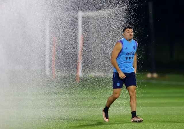 Argentina's Marcos Acuna reacts during training as a sprinkler sprays