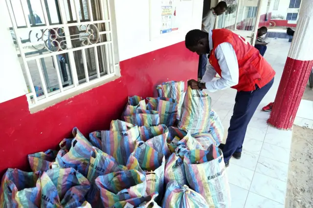 A member of the Gambian Red Cross looks through sacks of collected cough syrups in Banjul on October 06, 2022