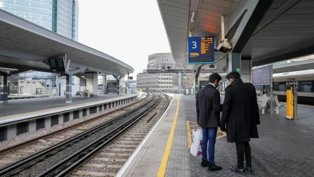 Two men standing on a train platform