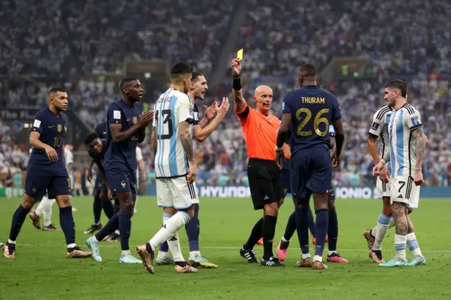 Marcus Thuram of France is shown a yellow card by referee Szymon Marciniak during the FIFA World Cup Qatar 2022 Final match between Argentina and France at Lusail Stadium