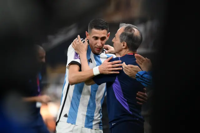 Argentina's coach hugs Angel di Maria after the forward is taken off in the 2022 World Cup final against France