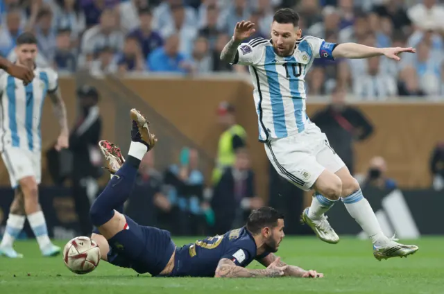 Theo Hernandez of France and Lionel Messi of Argentina challenge during the FIFA World Cup Qatar 2022 Final match between Argentina and France at Lusail Stadium