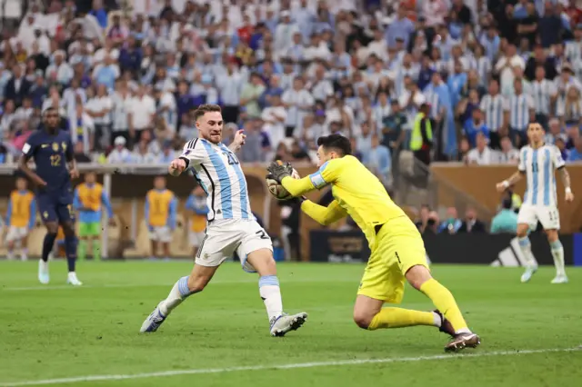 Hugo Lloris beats Alexis Mac Allister to the ball in the box