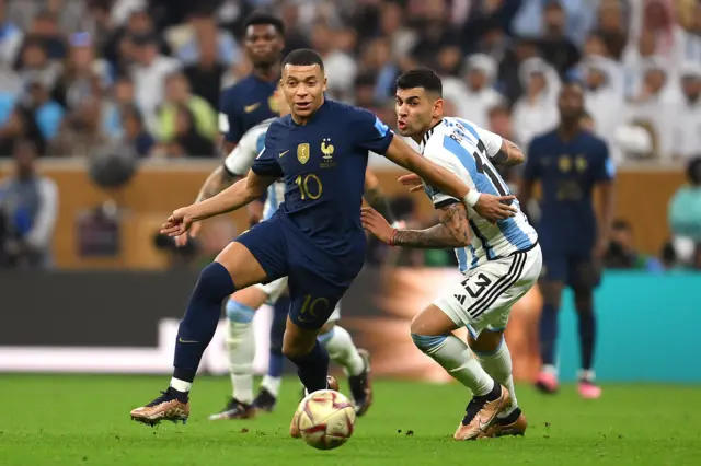 Cristian Romero tackles Kylian Mbappe