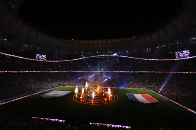 Pyrotechnics surround a giant FIFA World Cup trophy prior to the FIFA World Cup Qatar 2022 Final match between Argentina and France at Lusail Stadium