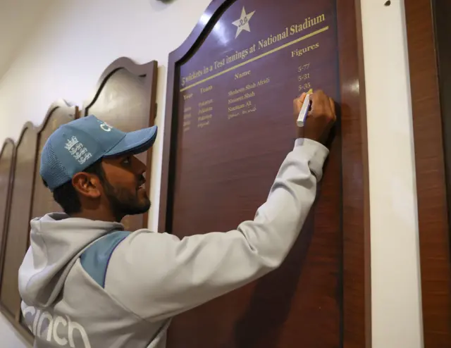 Rehan Ahmed writing his name on the honours board at the Karachi Stadium