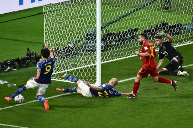 Japan's forward #09 Kaoru Mitoma (L) crosses the ball for his team's second goal during the Qatar 2022 World Cup Group E football match between Japan and Spain at the Khalifa International Stadium in Doha