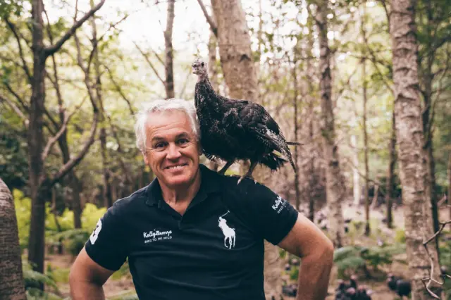 Turkey farmer Paul Kelly with a bird perched on his shoulder