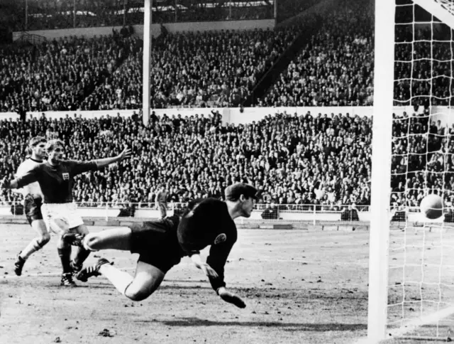 West Germany's goalkeeper Hans Tilkowski watches the ball bounce off the crossbar following a shot by English forward Geoff Hurst (not pictured) as English forward Roger Hunt (arms raised) and West Germany's defender Wolgang Weber look on during the overtime period of the World Cup final on July 30, 1966 at Wembley stadium in London. After consulting Soviet linesman Tofik Bakhramov, Swiss referee Gottfried Dienst validated the goal as England went on to defeat West Germany 4-2, with Hurst scoring three goals, to win its first World Cup title.