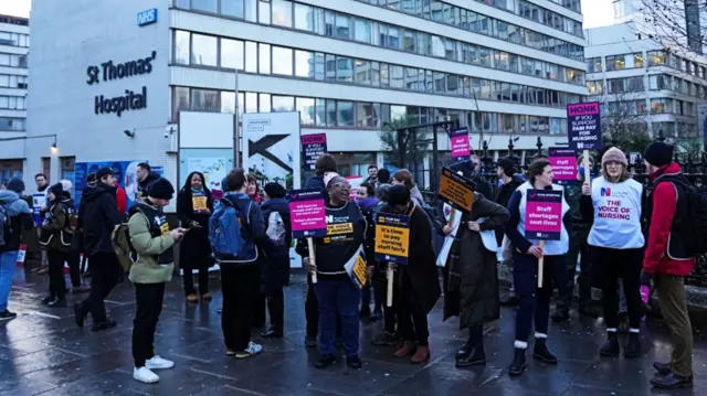 NHS nurses hold placards during a strike outside St Thomas' Hospital in London