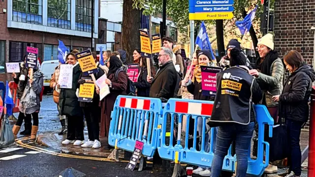 A crowd of nurses holding signs on the picket lines outside St Mary's Hospital