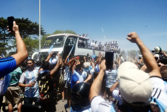 Argentina players are pictured on a bus with the World Cup trophy during the victory parade as fans celebrate