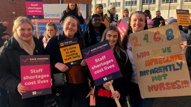 Nurses on strike in Leeds hold placards outside Leeds General Infirmary