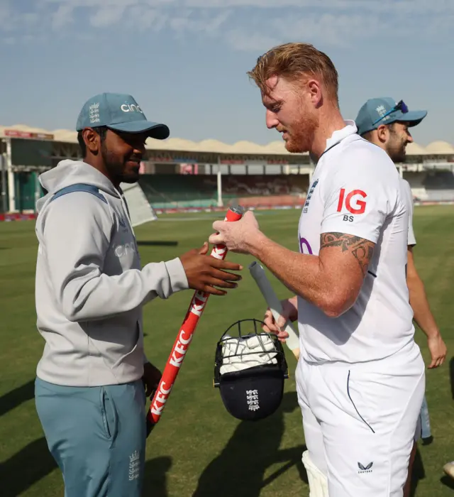 Ben Stokes giving Rehan Ahmed one of the stumps