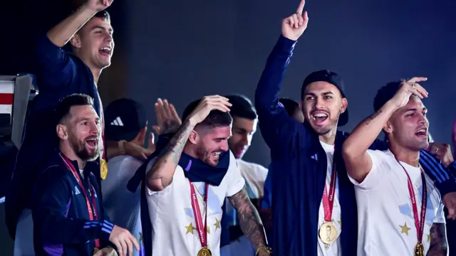 The Argentina team celebrate on their open-top bus after landing back in Buenos Aires