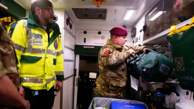 A man in military uniform and a paramedic inside an ambulance