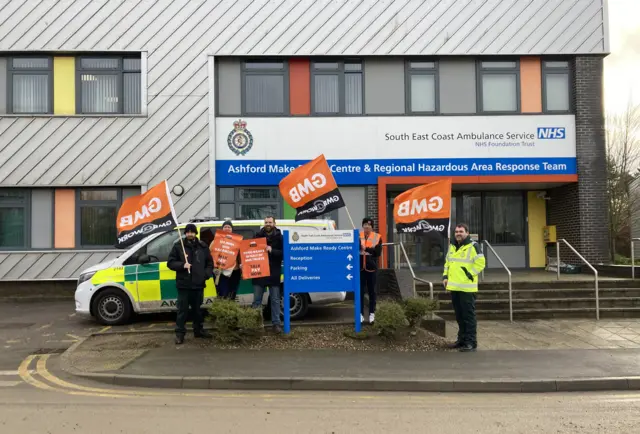 Image of ambulance workers striking in Ashford, Kent, and holding GMB flags