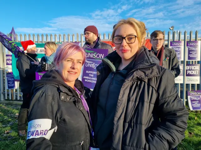 Wendy Smith and Paige Orton pictured on a picket line in Hull, with fellow strikers holding placards