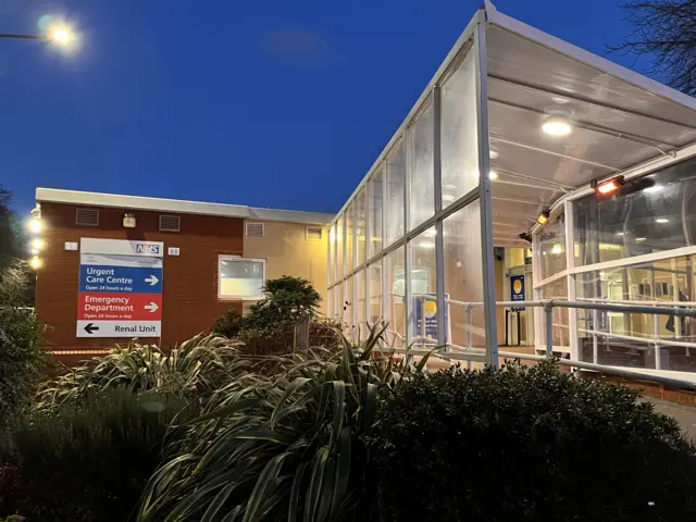 A view of the outside of West Middlesex Hospital at dusk - with no patients in sight