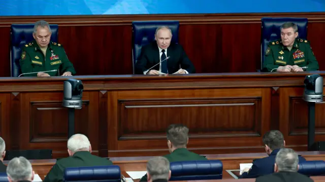 Vladimir Putin, alongside Russian Defence Minister Sergei Shoigu and Chief of the Russian General Staff Valery Gerasimov, makes a speech to the Russian people